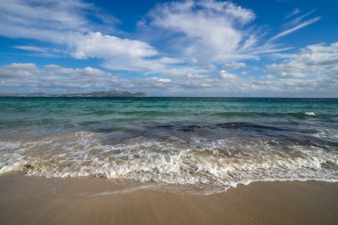Mayorka adasındaki Akdeniz plajı veya Mallorca, İspanya 'nın bir parçası olan ve Akdeniz' de bulunan Balear Adaları 'nın en büyük plajıdır. Deniz kenarında tatiller, bulutlar, deniz manzarası. Deniz ve ada manzarası.  