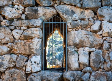 old stone antique wall with closed grate door