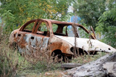 burned out blown up car against the background of a destroyed house war between Russia and Ukraine