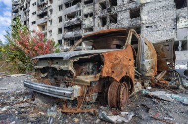 burned out blown up car against the background of a destroyed house war between Russia and Ukraine