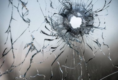 bullet hole in window glass with cracks abstract background close war clipart