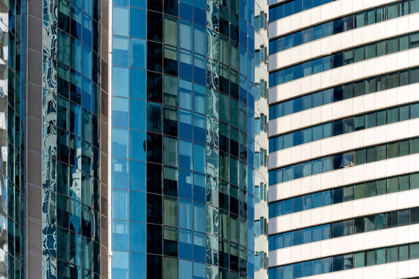 Many windows and walls facade of a modern skyscraper without people architectural abstract pattern
