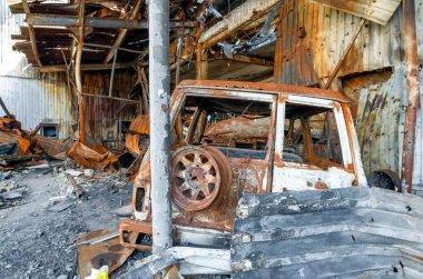 burnt military armored car on the street of the ruined city war Ukraine Russia