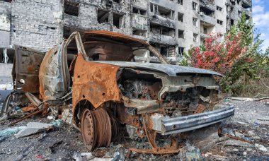 burned out blown up car against the background of a destroyed house war between Russia and Ukraine