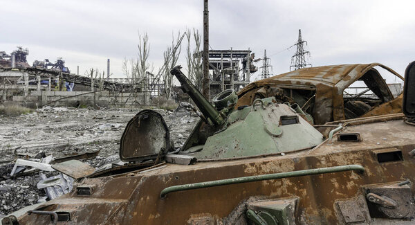 сгоревший танк и разрушенные здания цеха завода "Азовсталь" в Мариупольской войне с Россией