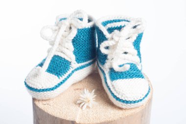 Beyaz arka planda izole edilmiş yün ayakkabılar örülmüş.