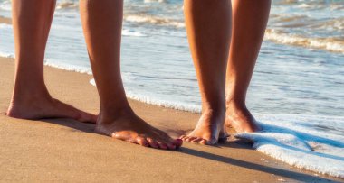 yaz closeup deniz sörf dalgalarında kumlu bir plajda kadın ayakları