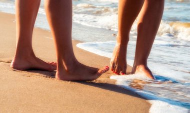 yaz closeup deniz sörf dalgalarında kumlu bir plajda kadın ayakları