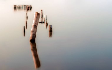 suyun sakin bir yüzeyde ahşap sütunlar