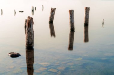 suyun sakin bir yüzeyde ahşap sütunlar