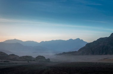 Gece çöl manzarası kayalık dağlar ve günbatımı gökyüzü Sharm El Sheikh Mısır 'da bulutlar