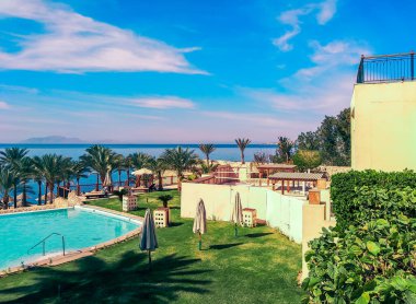 Güney Sina kıyısında katlanmış şemsiyeli boş bir otel çimenliği. Mısır Sharm El Sheikh.