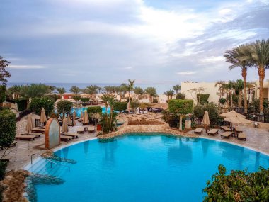 Güney Sina kıyısında katlanmış şemsiyeli boş bir otel çimenliği. Mısır Sharm El Sheikh.