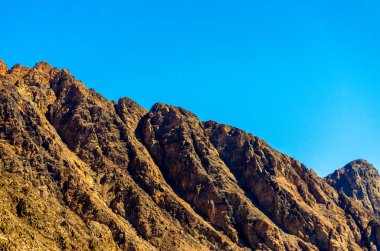 Mısır 'da mavi bir gökyüzüne karşı yüksek kayalık dağların zirveleri