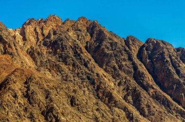 Mısır 'da mavi bir gökyüzüne karşı yüksek kayalık dağların zirveleri