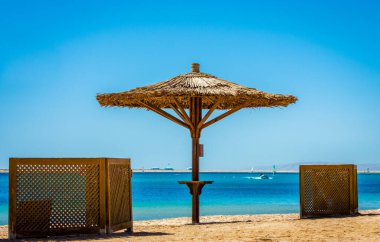 Denizin arka planda sazlık plaj şemsiyesi ve Mısır'da açık bir gökyüzü