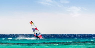 Sharm El Sheikh 'te açık bir gökyüzünün arka planında sörfçüler Kızıl Deniz' e biniyor.