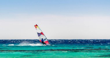 Mısır 'da açık bir gökyüzü arka planda Kızıldeniz sörfçü rides. Dahab