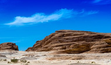 Mavi gökyüzü ve beyaz bulutlar Mısır Dahab South Sinai'deki / daki çölde karşı yüksek rocky Dağları
