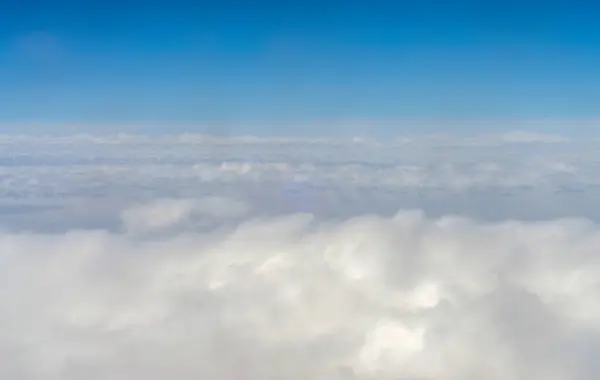 white clouds and blue sky view from airplane window