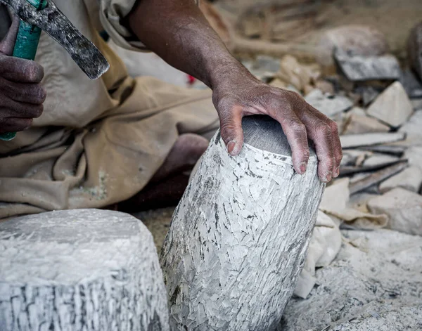 hands of a male Egyptian sculptor while working with a stone alabaster close up