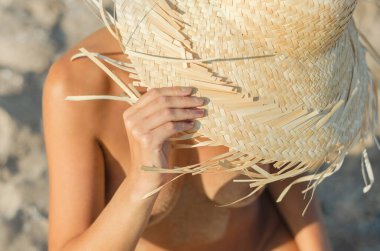 bir saman şapkalı genç kız plaj kapatmak kum oturur