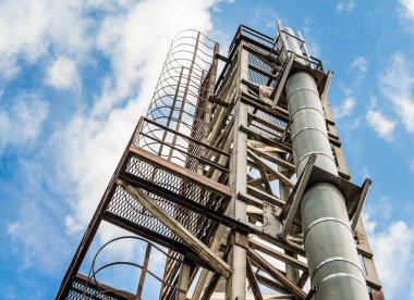 bir boru ve mavi bir gökyüzü ve bulutlar karşı bir merdiven ile kule