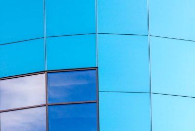 mavi panelleri ve yansıtılmış bir pencere ile yapı duvarına