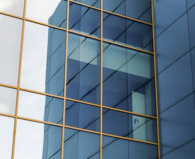 Ofis binasının ön cephesinde mavi paneller ve evin çarpık yansıması olan sarı pencere çerçeveleri vardı.