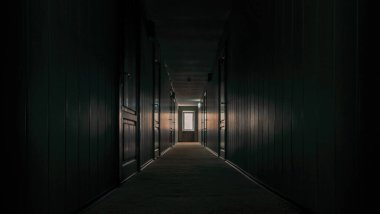 Karantina sırasında insansız, boş bir otelin kapalı kapıları olan kasvetli karanlık koridor.