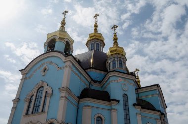 Mavi arka planda haçları olan Hristiyan kilisesinin altın kubbeleri.
