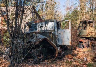 Sonbaharda Çernobil Ukrayna 'da ağaçların arasında terk edilmiş ekipman arabası