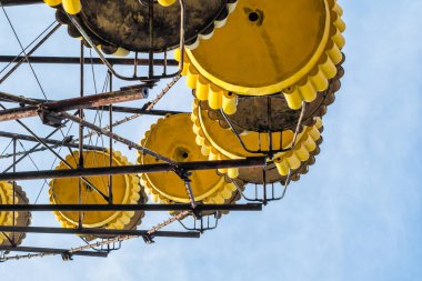 Çernobil Ukrayna 'da mavi gökyüzü ve bulutların arka planında terk edilmiş bir lunaparkta hiç kimse atlıkarınca kulübesine girmez.