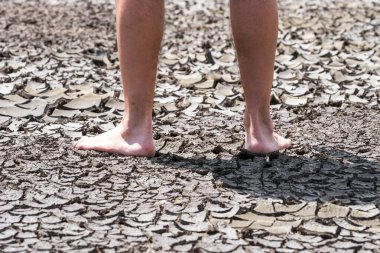 Kuru topraklarda bitkisiz bir insanın çıplak ayakları kötü ekoloji ve küresel ısınma