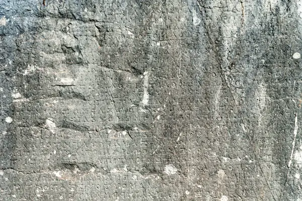 ancient greek letters in stone abstract background close up