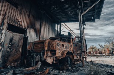 burnt military armored car on the street of the ruined city war Ukraine Russia