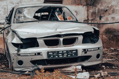 Ukrayna 'da bir şehir caddesinde Rusya ile savaşta terk edilmiş bir araba yağmacılar tarafından parçalandı.