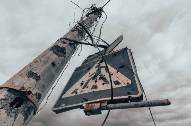 concrete pillar broken by shards and blue road sign against a gloomy sky in Mariupol Ukraine