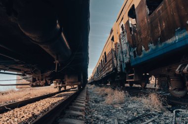 end of the road damaged and burnt trains war in Ukraine with Russia