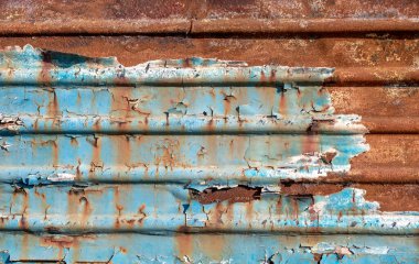 pattern rusty metal surface with remnants of blue paint close up