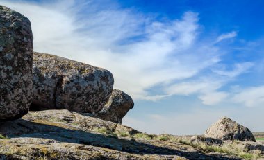 mavi bir gökyüzü ve beyaz bulutlar karşı büyük taşlar