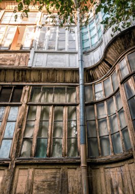 Gürcistan 'da ağaç dallarının yeşil yaprakları olan eski bir evin pencereleri.