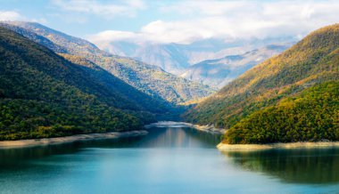 Gürcistan 'da yeşil ormanlık, göl, gökyüzü ve bulutlu sonbahar manzarası