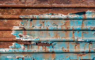 pattern rusty metal surface with remnants of blue paint close up