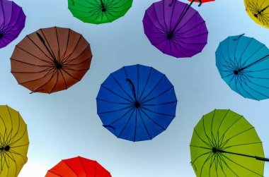 çok renkli şemsiyeler uçuyor ve soyut arka planda uçuyor.