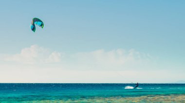 Mısır'da Kızıldeniz'de bulutların arka planına karşı bir yelken ile bir sörfçü