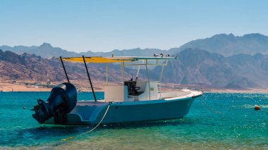 Mısır 'da yüksek kayalık dağlar ile sahile karşı denizde motorlu tekne