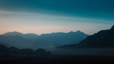 Gece çöl manzarası kayalık dağlar ve günbatımı gökyüzü Sharm El Sheikh Mısır 'da bulutlar