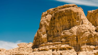 Mavi gökyüzü ve beyaz bulutlar karşı çölde yüksek rocky Dağları