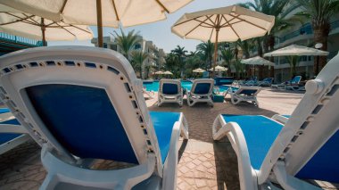 Hurghada 'da insanlar olmadan palmiye ağaçlarının altında boş plaj salonları